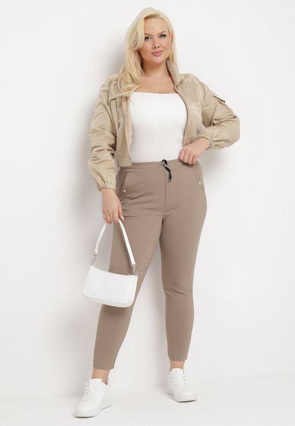 Born2be - Ciemnobeżowe Spodnie z Nogawkami 7/8 i Kieszeniami Gavotta. Okazja: na co dzień. Kolekcja: plus size. Kolor: beżowy. Materiał: satyna. Styl: elegancki, casual