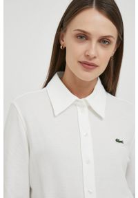 Lacoste koszula bawełniana damska kolor beżowy regular z kołnierzykiem klasycznym. Typ kołnierza: kołnierzyk klasyczny. Kolor: beżowy. Materiał: bawełna. Długość rękawa: długi rękaw. Długość: długie. Styl: klasyczny
