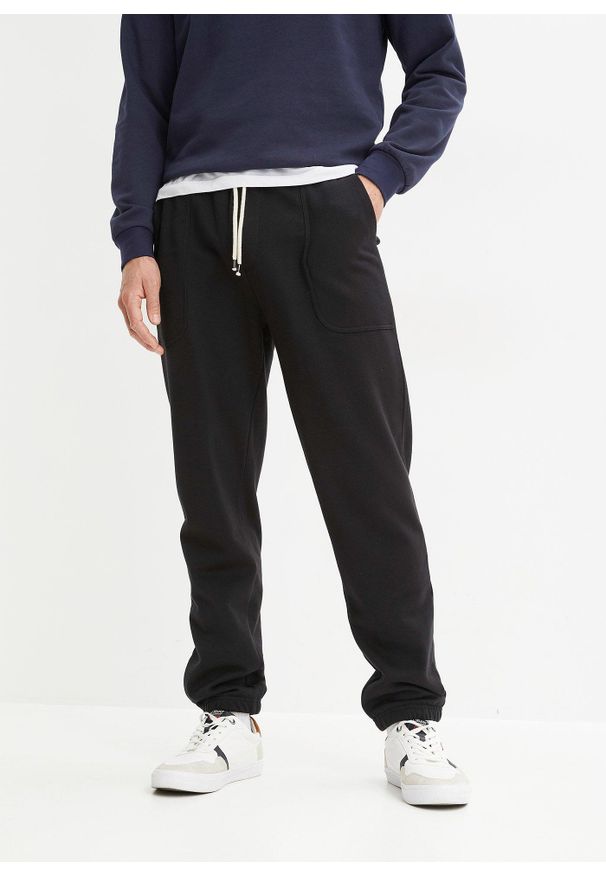 bonprix - Spodnie sportowe z czystej bawełny organicznej. Stan: obniżony. Kolor: czarny. Materiał: bawełna, dresówka. Styl: sportowy