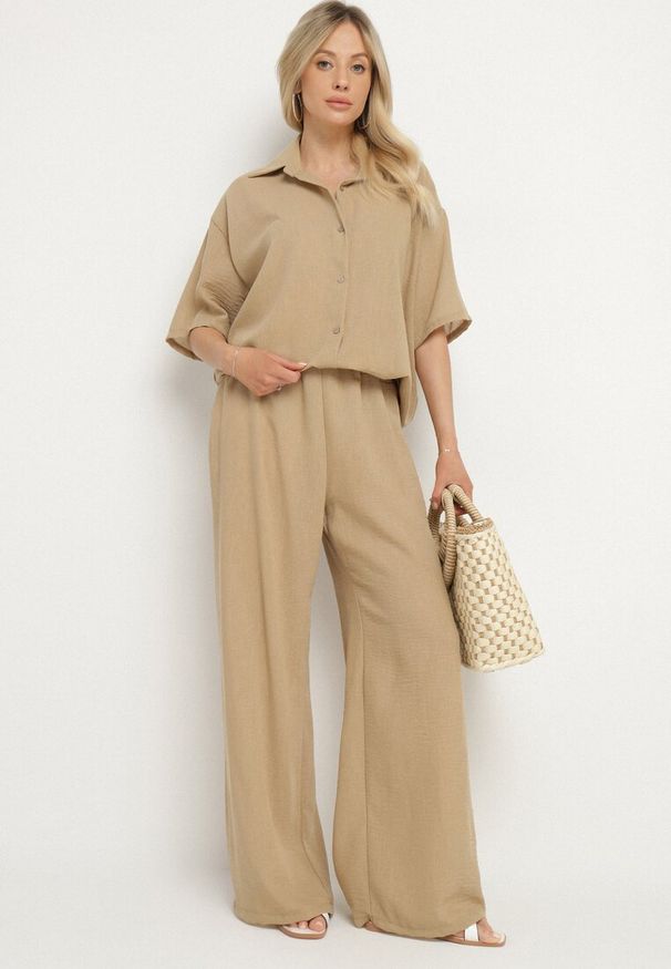 Born2be - Ciemnobeżowy Komplet 2-Częściowy Koszula o Luźnym Kroju Szerokie Spodnie z Gumką w Talii Vimitha. Kolor: beżowy. Materiał: materiał. Wzór: aplikacja