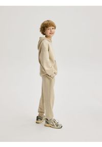 Reserved - Bawełniane joggery z meszkiem - beżowy. Kolor: beżowy. Materiał: bawełna