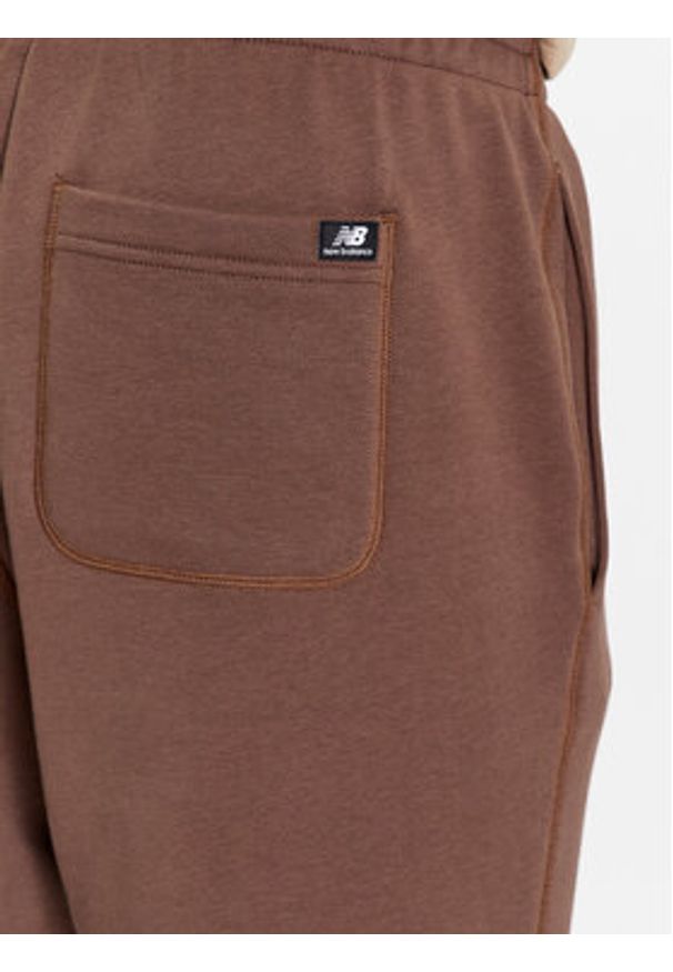 New Balance Spodnie dresowe NB Essentials Sweatpant MP33509 Brązowy Regular Fit. Kolor: brązowy. Materiał: bawełna