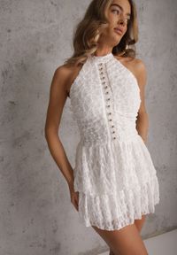Renee - Biała Sukienka Halter z Koronki Zdobiona Metalicznymi Guziczkami Corrarea. Typ kołnierza: dekolt halter. Kolor: biały. Materiał: koronka. Wzór: aplikacja, koronka #1