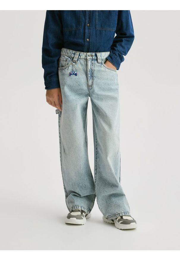 Reserved - Jeansy baggy z brelokiem - niebieski. Kolor: niebieski