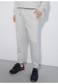 Ochnik - Kremowe spodnie dresowe męskie. Kolor: beżowy. Materiał: bawełna. Wzór: nadruk #1