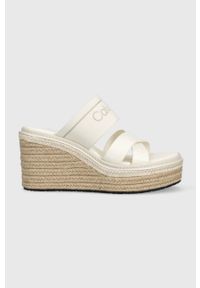 Calvin Klein klapki WEDGE 50HH - HE damskie kolor biały na koturnie HW0HW01498. Kolor: biały. Materiał: materiał, skóra, guma, włókno. Wzór: nadruk. Obcas: na koturnie