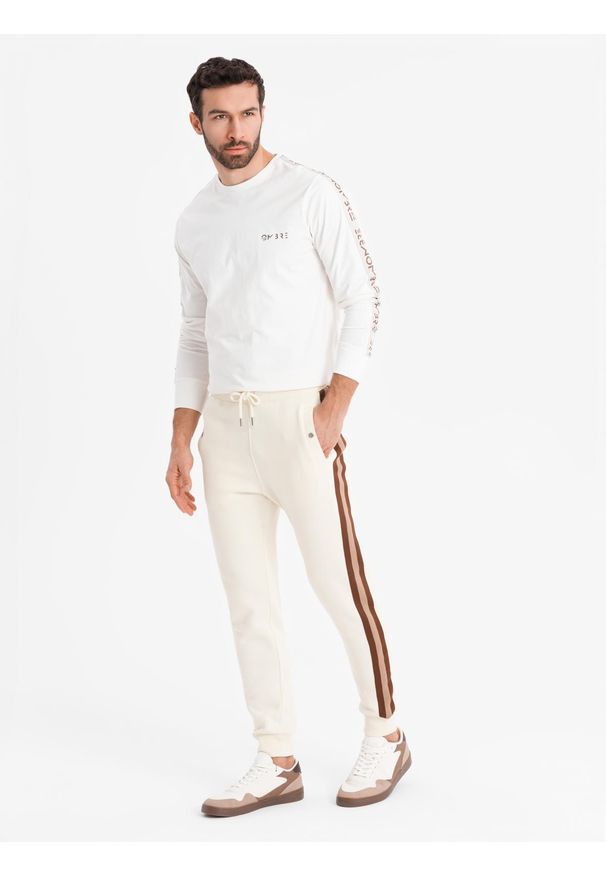 Ombre Clothing - Dresowe męskie spodnie z lampasami i ściągaczami na nogawkach – kremowe V3 OM-PASK-0258 - XXL. Kolor: kremowy. Materiał: dresówka. Wzór: aplikacja, kolorowy. Styl: retro, elegancki