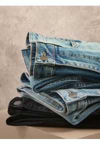 Reserved - Jeansy carrot slim z efektem sprania - niebieski. Kolor: niebieski