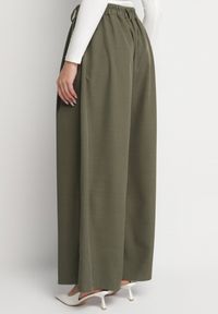 Born2be - Ciemnozielone Spodnie o Fasonie Palazzo z Wsuwanymi Kieszeniami Adivena. Okazja: na co dzień. Stan: podwyższony. Kolor: zielony. Materiał: jedwab. Długość: długie. Styl: elegancki, casual #7