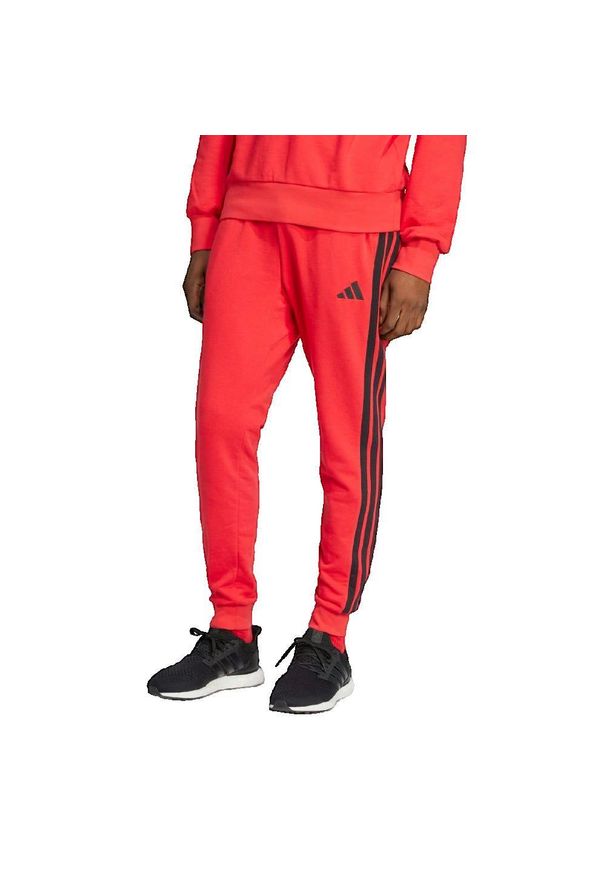 Spodnie Mężczyzna Adidas Essential 3 Stripes czerwony. Kolor: czerwony. Materiał: dresówka. Styl: sportowy, elegancki