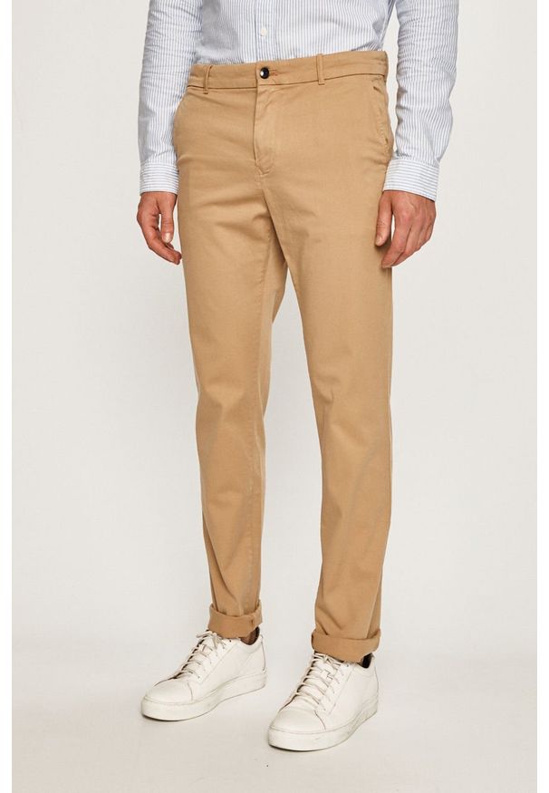 Calvin Klein - Spodnie. Kolor: beżowy. Materiał: tkanina, bawełna, materiał, elastan. Wzór: gładki