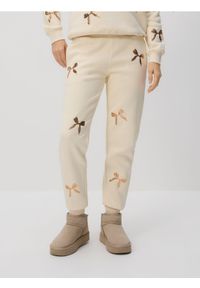 Reserved - Spodnie dresowe z aplikacjami - złamana biel. Materiał: dresówka. Wzór: aplikacja #1