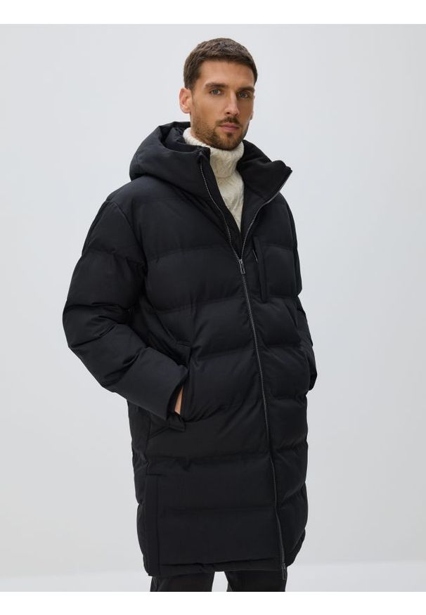 Reserved - Długa pikowana kurtka z kapturem - czarny. Typ kołnierza: kaptur. Kolor: czarny. Materiał: tkanina. Długość: długie