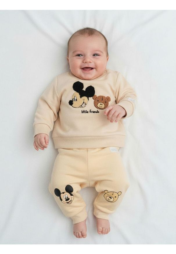 Sinsay - Spodnie z polarem w środku Mickey Mouse - kremowy. Kolor: kremowy. Materiał: polar. Wzór: motyw z bajki