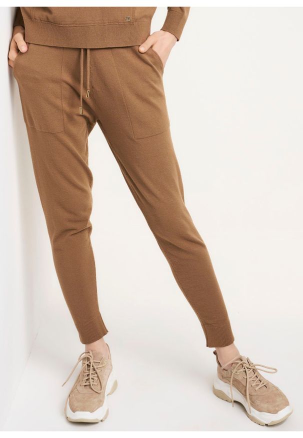 Ochnik - Beżowe spodnie dresowe damskie. Okazja: na co dzień. Kolor: beżowy. Materiał: materiał. Styl: casual