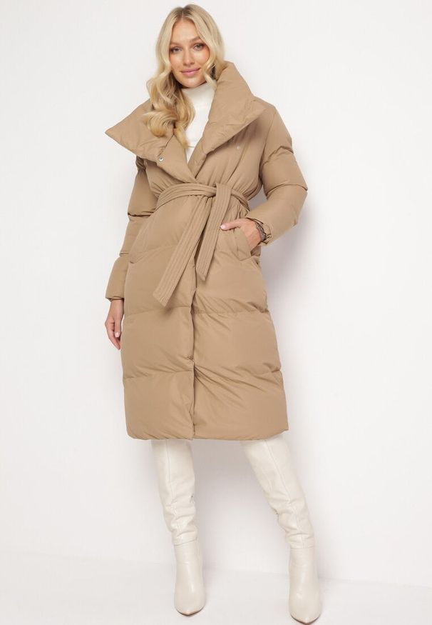 Born2be - Ciemnobeżowa Kurtka Płaszcz Zapinana na Napy Ukryte pod Plisą z Kieszeniami i Paskiem Ritallas. Typ kołnierza: kołnierzyk stójkowy. Kolor: beżowy. Materiał: materiał. Długość: długie. Sezon: zima