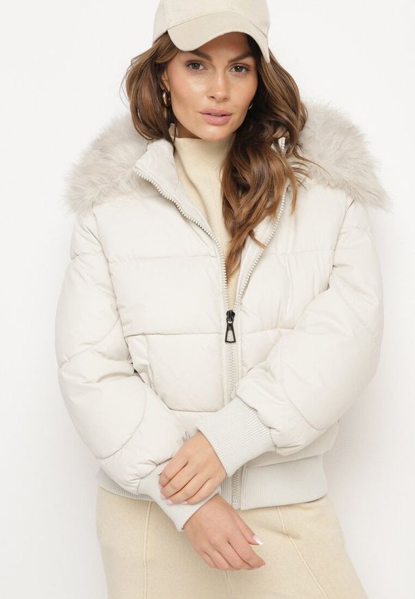 Born2be - Jasnobeżowa Pikowana Kurtka z Szerokimi Ściągaczami i Ozdobnym Futrem przy Kapturze Inandria. Okazja: do pracy, na co dzień, na spotkanie biznesowe. Kolor: beżowy. Materiał: futro. Długość rękawa: długi rękaw. Długość: długie. Styl: klasyczny, casual, elegancki, biznesowy