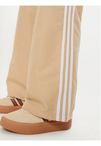 Adidas - adidas Spodnie dresowe adicolor 3-Stripes IZ0717 Beżowy Loose Fit. Kolor: beżowy. Materiał: syntetyk