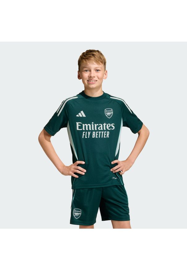 Adidas - Dziecięca koszulka Arsenal Tiro 25 Competition Training. Kolor: niebieski. Materiał: dzianina. Sport: piłka nożna