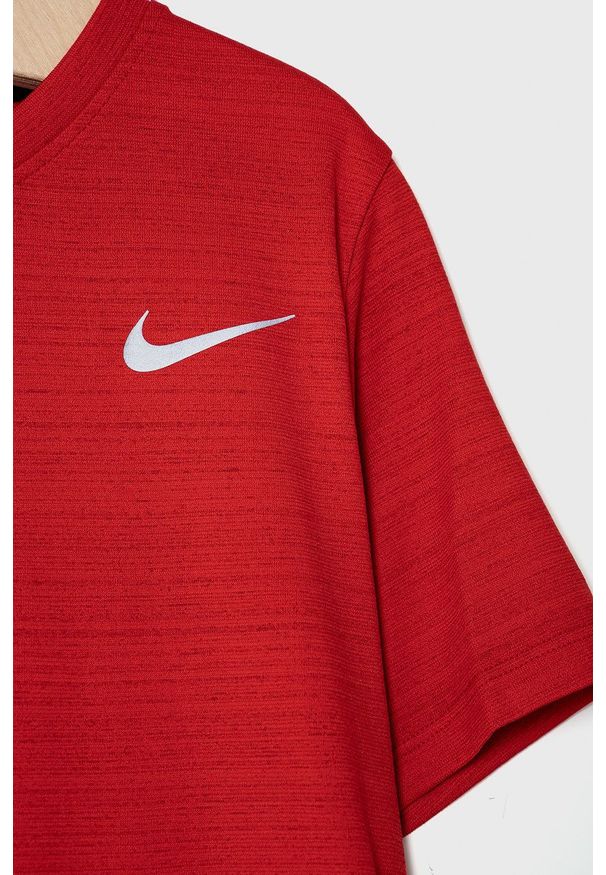 Nike Kids T-shirt dziecięcy kolor czerwony gładki. Okazja: na co dzień. Kolor: czerwony. Materiał: dzianina, skóra, włókno, tkanina. Wzór: gładki. Styl: casual