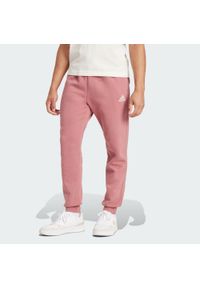 Adidas - Essentials Fleece Regular Tapered Pants. Kolor: czerwony, wielokolorowy, różowy, czarny. Materiał: materiał