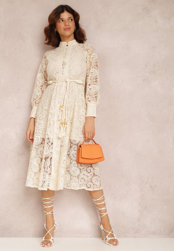 Renee - Jasnobeżowa Sukienka Palestra. Okazja: na wesele, na imprezę, na ślub cywilny. Typ kołnierza: kołnierzyk stójkowy, dekolt gorset. Kolor: beżowy. Materiał: koronka, bawełna. Długość rękawa: długi rękaw. Typ sukienki: gorsetowe. Styl: boho, elegancki, wizytowy. Długość: midi