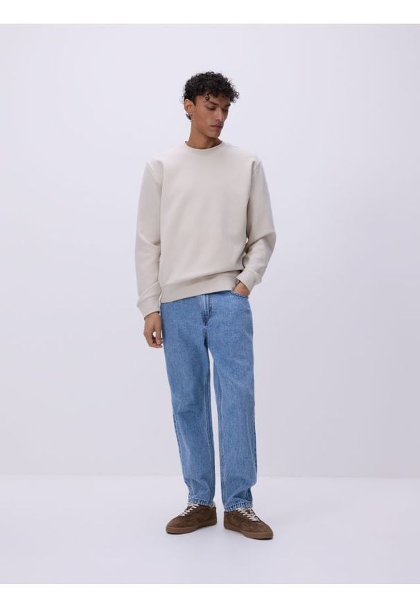 Reserved - Jeansy carrot z efektem sprania - niebieski. Kolor: niebieski