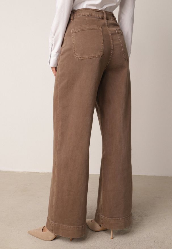 Born2be - Brązowe Bawełniane Jeansy o Szerokim Kroju z Wysokim Stanem Kyltyse. Okazja: do pracy, na co dzień. Stan: podwyższony. Kolor: brązowy. Długość: krótkie. Styl: casual