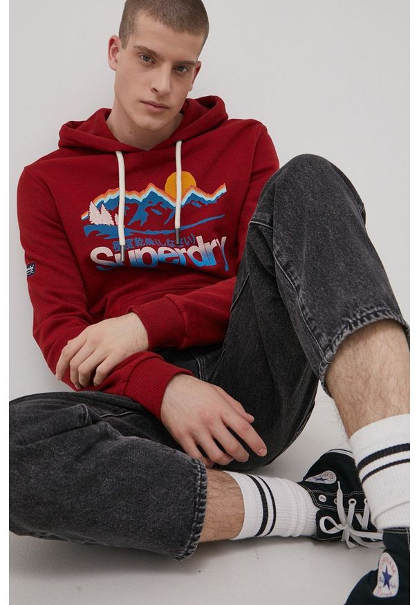 Superdry Bluza męska kolor czerwony z kapturem z nadrukiem. Typ kołnierza: kaptur. Kolor: czerwony. Materiał: dzianina. Wzór: nadruk