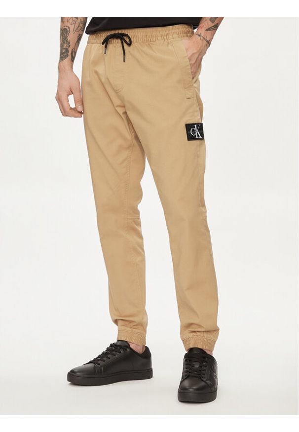 Calvin Klein Jeans Joggery Monologo Badge J30J325114 Beżowy Skinny Fit. Kolor: beżowy. Materiał: bawełna