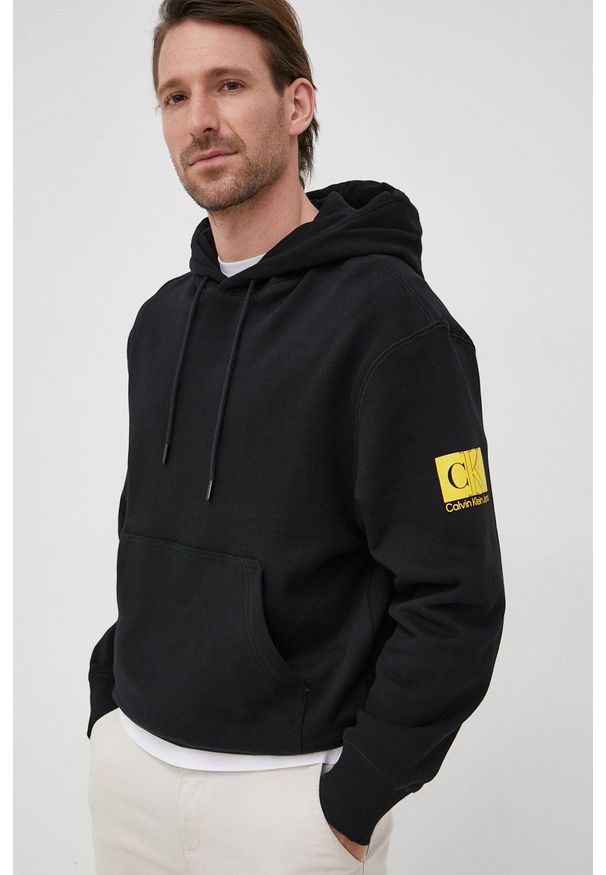 Calvin Klein Jeans bluza bawełniana męska kolor czarny z kapturem z nadrukiem. Typ kołnierza: kaptur. Kolor: czarny. Materiał: bawełna. Wzór: nadruk