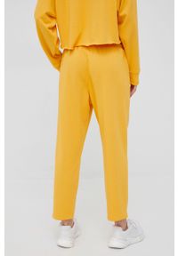 DKNY - Dkny spodnie dresowe damskie kolor żółty z nadrukiem. Kolor: żółty. Materiał: dresówka. Wzór: nadruk