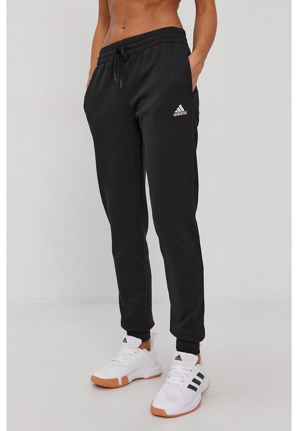 Adidas - adidas Spodnie damskie kolor czarny gładkie. Kolor: czarny. Materiał: bawełna. Wzór: gładki