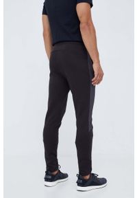 Puma spodnie treningowe Evostripe kolor czarny z nadrukiem. Kolor: czarny. Materiał: skóra, materiał. Wzór: nadruk #2