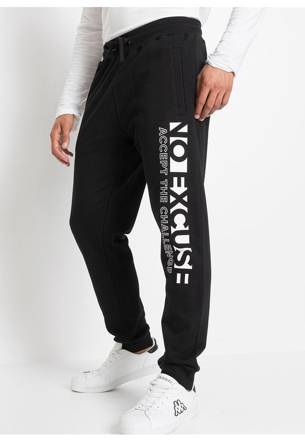 bonprix - Spodnie ze sportowym nadrukiem uszyte z czystej bawełny. Kolor: czarny. Materiał: bawełna. Wzór: nadruk. Styl: sportowy