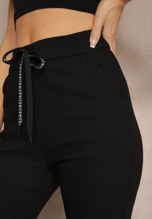 Renee - Czarne Spodnie z Bawełną High Waist z Napisami oraz Gumką w Talii Rilaira. Okazja: na spotkanie biznesowe, do pracy. Stan: podwyższony. Kolor: czarny. Materiał: bawełna. Wzór: napisy. Styl: elegancki, biznesowy