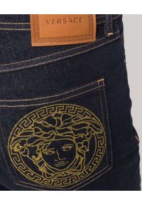 VERSACE - Jeansy z dużym logo na kieszeni. Kolor: niebieski. Wzór: aplikacja
