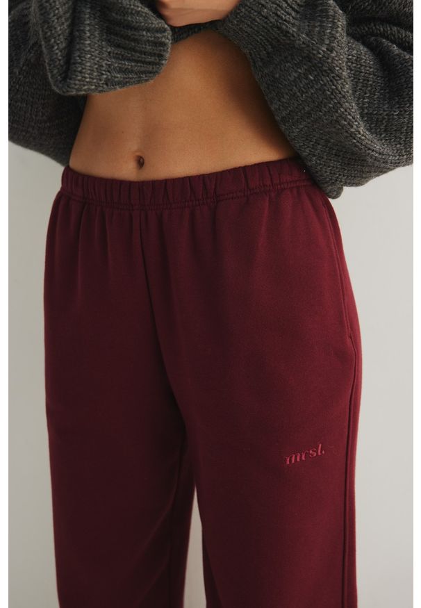 Marsala - Spodnie typu jogger z HAFTEM w kolorze BURGUNDY - NEVIS-XL. Stan: obniżony. Materiał: dzianina, poliester, bawełna, guma. Wzór: haft. Styl: elegancki