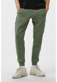 Guess - GUESS Zielone męskie spodnie dresowe z lampasami Mickey, Rozmiar XL. Kolor: zielony. Materiał: dresówka #1