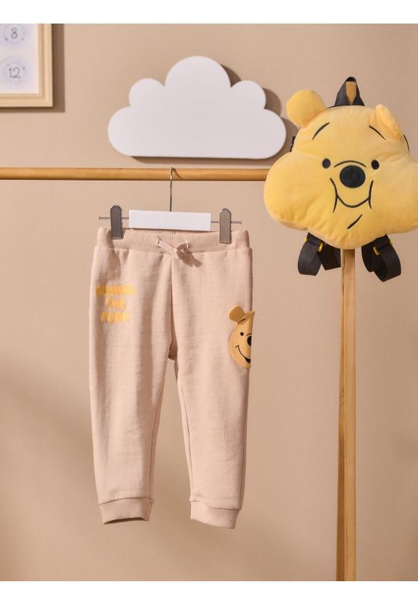 Sinsay - Spodnie z elementami 3D Winnie the Pooh - beżowy. Kolor: beżowy