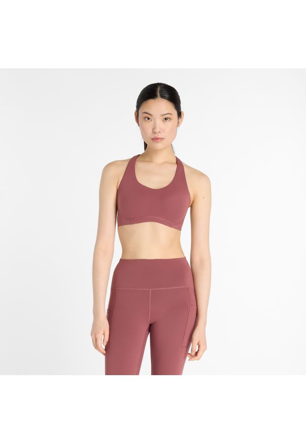 Biustonosz New Balance WB51052WAD – różowy. Kolor: różowy. Materiał: skóra, poliester, lycra, materiał, tkanina. Wzór: gładki. Sport: fitness