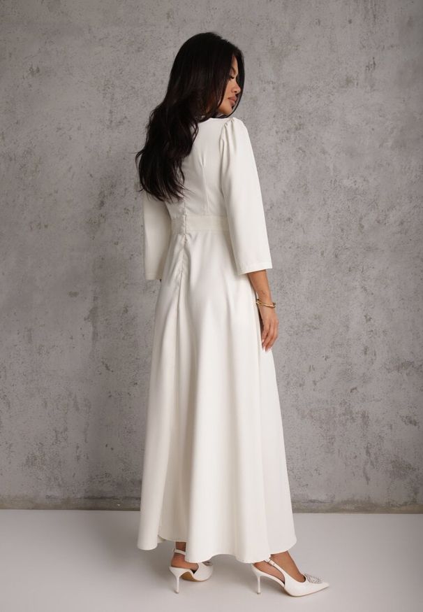 Renee - Jasnobeżowa Elegancka Sukienka o Kopertowym Kroju Zdobiona Aplikacją w Talii Zilendra. Kolor: beżowy. Wzór: aplikacja. Typ sukienki: kopertowe. Styl: elegancki