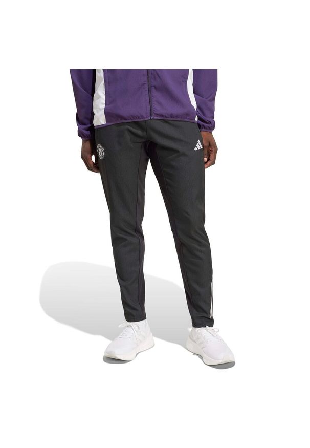 Adidas - Spodnie dresowe Prematch Manchester United 2025/26. Kolor: czarny. Materiał: dresówka. Sport: piłka nożna