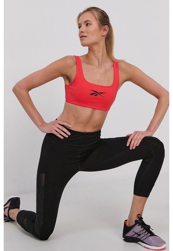Reebok Classic - Biustonosz sportowy. Kolor: pomarańczowy. Rodzaj stanika: odpinane ramiączka. Wzór: nadruk