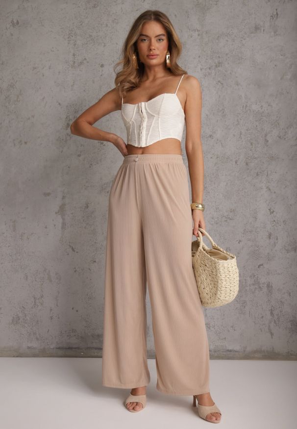 Renee - Beżowe Szerokie Spodnie High Waist z Prążkowanej Tkaniny z Ozdobnym Guzikiem Dalifa. Stan: podwyższony. Kolekcja: plus size. Kolor: beżowy. Materiał: tkanina, prążkowany. Długość: krótkie. Styl: glamour