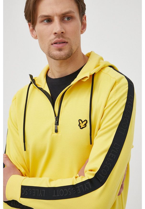 Lyle & Scott bluza męska kolor żółty z kapturem z aplikacją. Typ kołnierza: kaptur. Kolor: żółty. Materiał: poliester, materiał. Długość rękawa: raglanowy rękaw. Długość: krótkie. Wzór: aplikacja