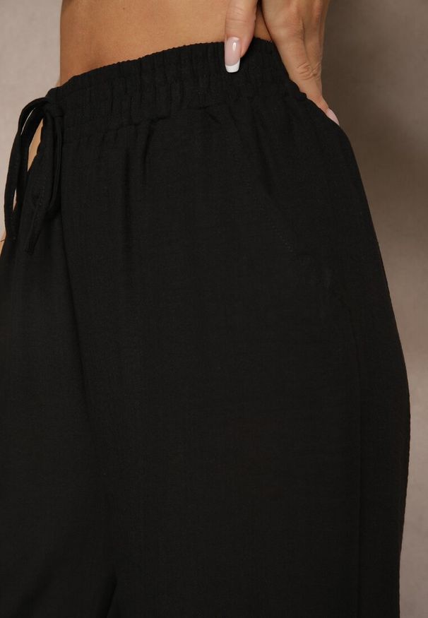 Renee - Czarne Szerokie Spodnie Palazzo High Waist z Ozdobnym Wiązaniem Arandiel. Okazja: na co dzień. Stan: podwyższony. Kolor: czarny. Materiał: jedwab. Styl: street, wizytowy, casual