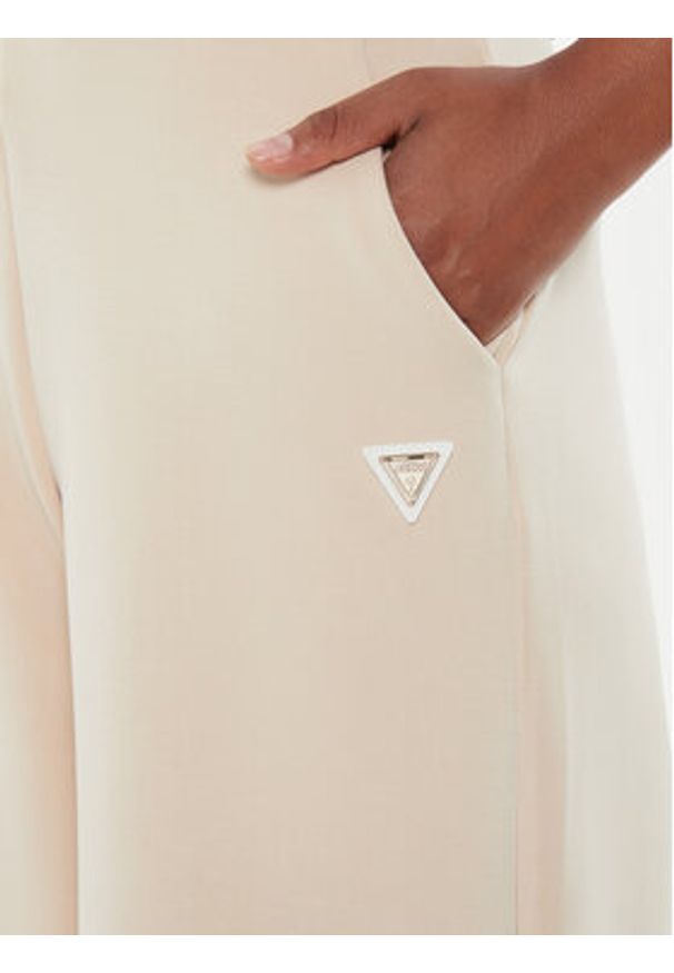 Guess Spodnie dresowe V4YB07 KCAY2 Beżowy Relaxed Fit. Kolor: beżowy. Materiał: syntetyk