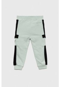 Guess spodnie dresowe bawełniane dziecięce kolor turkusowy wzorzyste. Stan: podwyższony. Kolor: turkusowy. Materiał: bawełna, dresówka #2