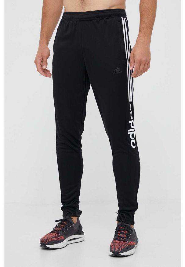 Adidas - adidas spodnie dresowe kolor czarny z nadrukiem. Kolor: czarny. Materiał: dresówka. Wzór: nadruk